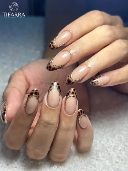 Who said fierce can’t be feminine? A modern take on French tips with a hand-painted leopard print design, outlined in gold chrome.