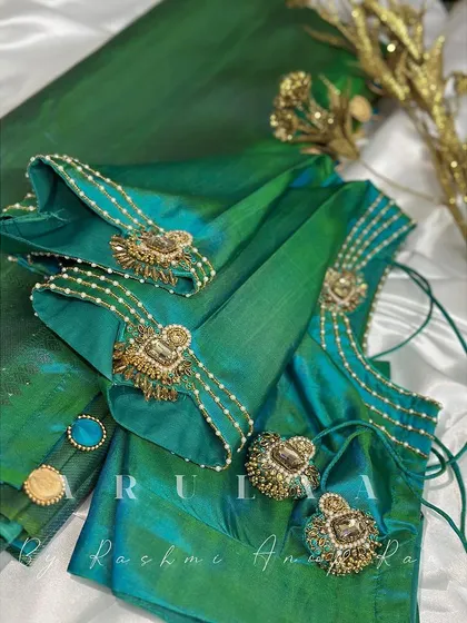 A green blouse with unique sleeve detailing. We've used antique gold brooches and pearl strings to create a jewelry-like effect on the sleeves.