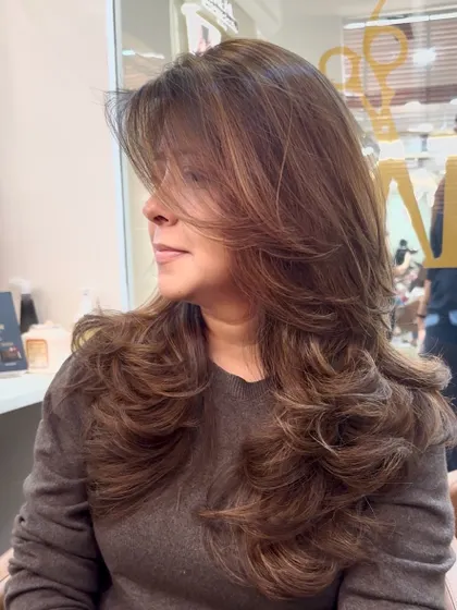 The final result of the hair color and layered cut transformation. The soft curls at the ends really make the layers pop.