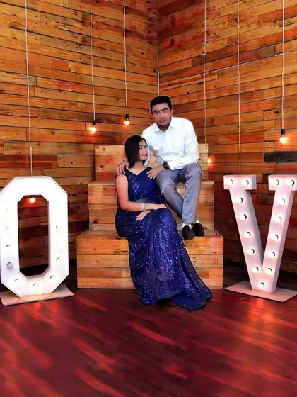 An indoor pre-wedding shoot with a 'LOVE' marquee light setup. We utilize creative studio props and lighting to produce stylish and modern couple portraits.