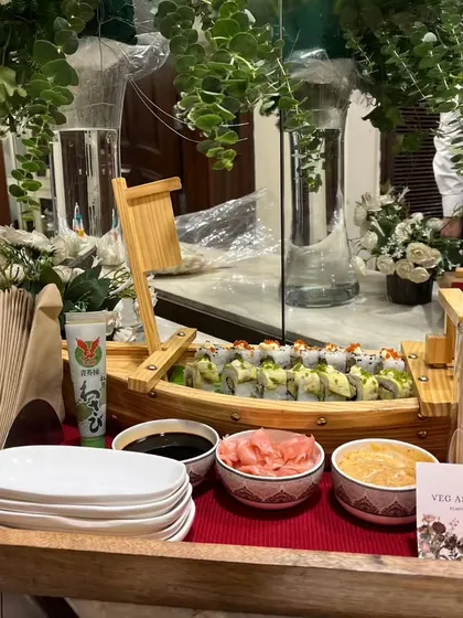 Our Veg Assorted Sushi is beautifully presented on a wooden tray with fresh greenery. We provide everything needed, including plates, chopsticks, and condiments, for a complete sushi experience.