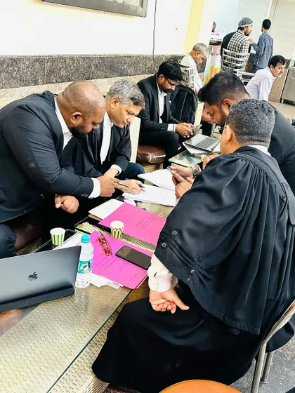 Deep in discussion, analyzing every aspect of the case with senior advocates.