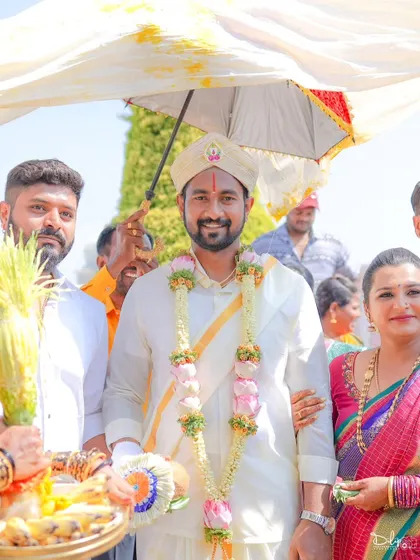 A happy portrait of the groom during his wedding procession, surrounded by family.