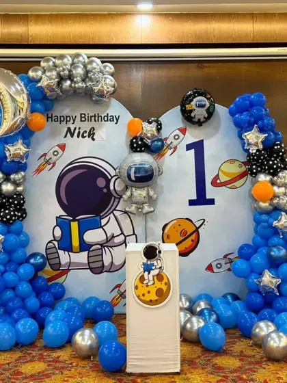 This shot shows the complete astronaut theme, including the cake pedestal and surrounding floor balloons.