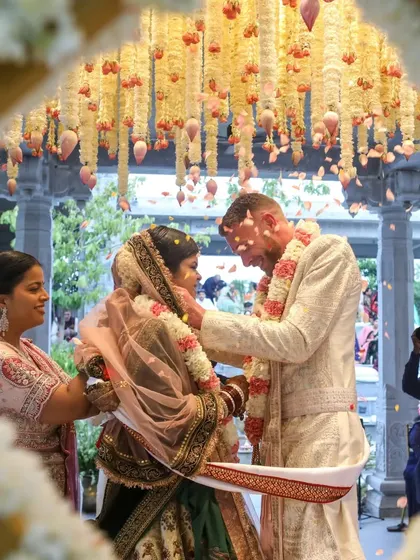 A moment of pure connection. Framed by a cascade of flowers, the couple exchanges garlands in a ritual that is both timeless and deeply personal. We design these moments to feel as beautiful as they are meaningful.