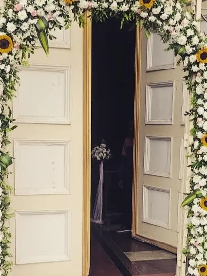 A beautiful floral arch is a classic way to welcome guests. This arch, made with an abundance of white flowers and cheerful sunflowers, creates a fresh and inviting entrance for a daytime event, baby shower, or intimate reception.