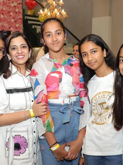 A group of older kids and a parent enjoying the party atmosphere.