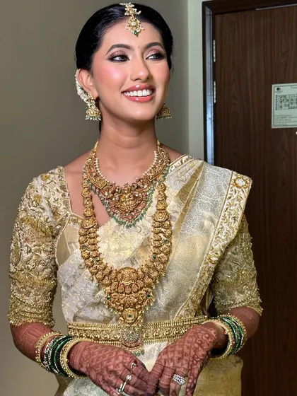 A beautiful candid shot of the bride. Her elegant off-white saree and custom embroidered blouse are perfect for a traditional South Indian wedding.