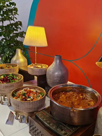 A beautiful display of fresh salads and a hot main course at the Air India launch event. We use elegant serveware, like these elevated bamboo bowls, to create a visually interesting buffet line.
