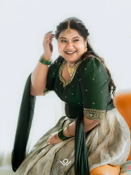 A candid and joyful portrait of a bride in a traditional South Indian half-saree.