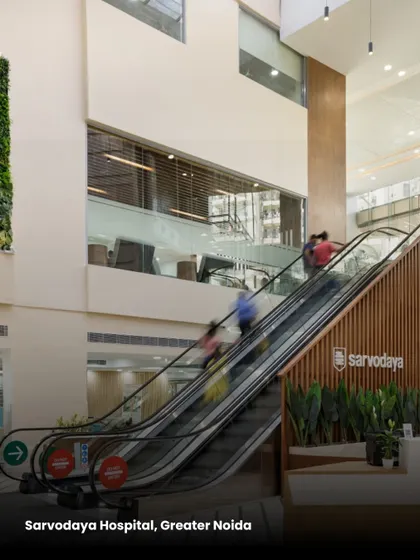 At Sarvodaya Hospital, an escalator in the central atrium connects two levels, enhancing vertical circulation. The design uses open, multi-story spaces to create visual connections and a sense of grandeur.