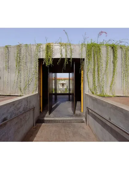 A view looking out from the entrance of the memorial gallery. The design uses the doorway to frame the landscape and the central water feature, creating a carefully composed experience for visitors as they move through the space.