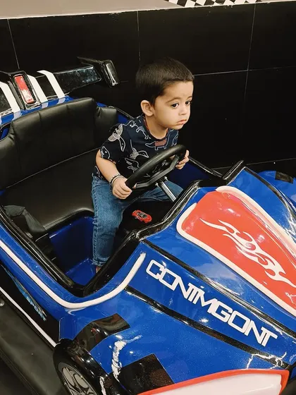 A toddler enjoys some free play time in a stationary bumper car at our Ashok Vihar center, engaging in imaginative play.