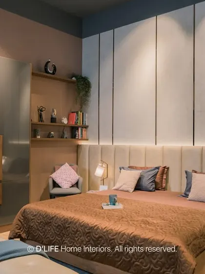A luxurious bedroom design with a floor-to-ceiling upholstered headboard and integrated backlighting. The glossy grey wardrobe and rich textiles create a sophisticated and restful ambiance.