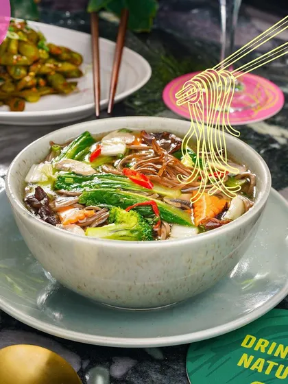 A warm bowl of vegetable pho, with chopsticks ready to dive in.