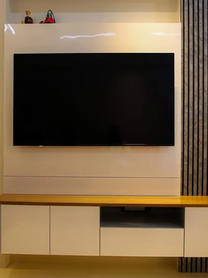 A close-up of a floating TV console featuring a stunning feather-motif bas-relief panel with backlighting, adding an artistic and delicate touch.