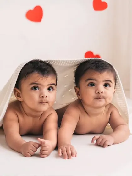 Peek-a-boo with six-month-old twins! This playful shot captures their budding personalities and the fun of a milestone photography session.
