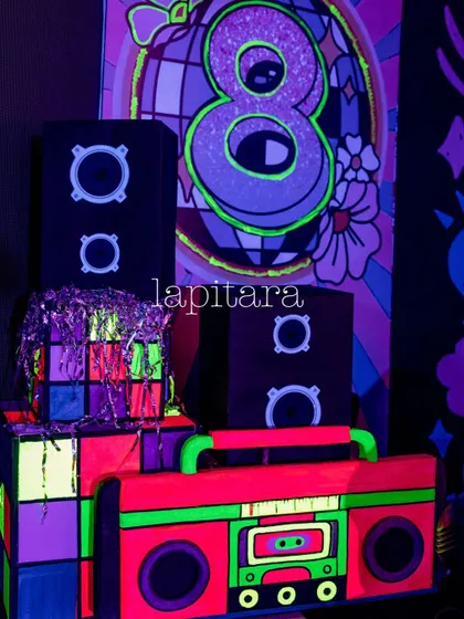 A detailed shot of a neon party prop, featuring a boombox and speaker design that glows under blacklight.