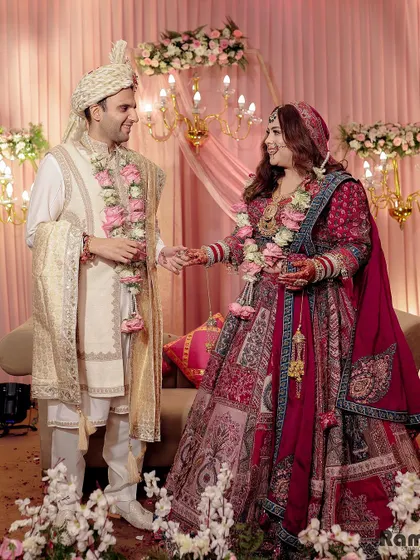A happy, candid shot of the couple on their wedding stage, sharing a laugh and holding hands.