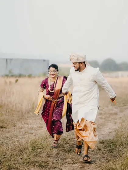 A fun, running shot of the couple in a field, capturing the energy and excitement of their wedding day.