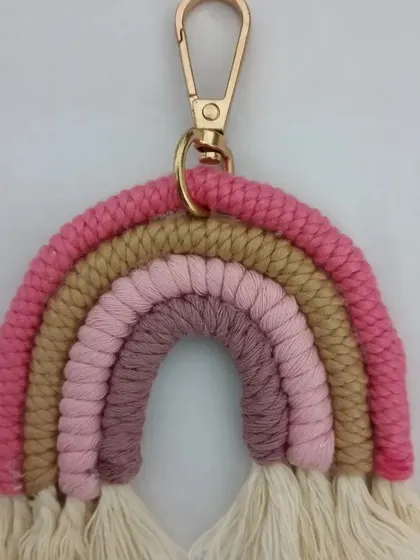 A rainbow keychain in shades of pink and beige, with a gold clasp.