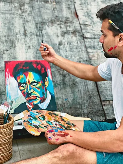 A shot of me working on the Al Pacino painting, surrounded by my paints and brushes. The process can be messy, but the result is always worth it.