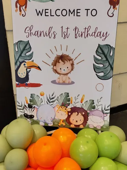 Welcome your guests to a wild adventure with our jungle-themed first birthday decor. This welcome sign, featuring adorable safari animals and a garland of green and orange balloons, is the perfect way to introduce your party's theme right from the entrance.