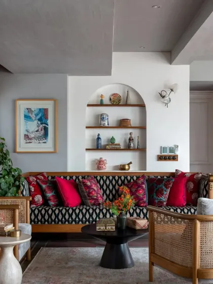 A living room vignette from the Dhaka project, showing the mix of patterned upholstery, an arched niche with curated objects, and a beautiful piece of art. This is an example of my "curated maximalist" style.