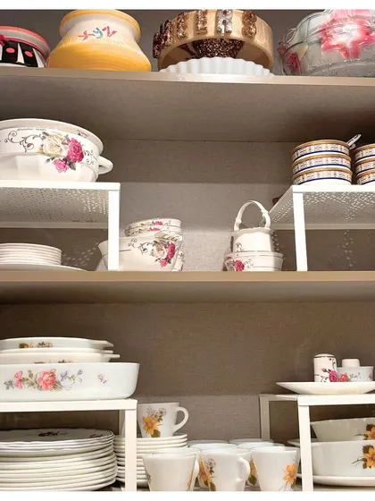 Even a simple crockery set can look elegant with the right organization. Using shelf risers helps to stack plates and bowls safely while creating more room for other items.