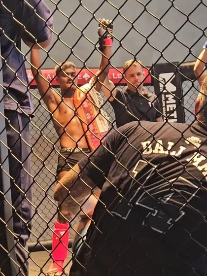 A fighter celebrates his victory inside the cage at Bali MMA.