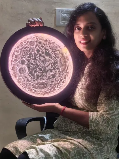 Here I am with my 3D moon texture painting. I use special techniques to build up the craters and surface details before installing the LED lights that bring it to life.