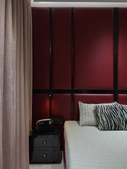 The heavy velvet curtain complements the luxurious feel of the red padded headboard.