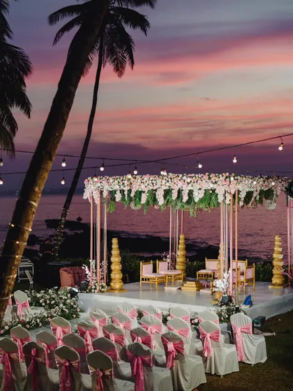A stunning view of a beachside mandap in Goa, set against a beautiful pink and purple sunset.
