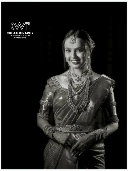 A timeless black and white portrait of the bride-to-be, highlighting her traditional jewelry and joyful expression.