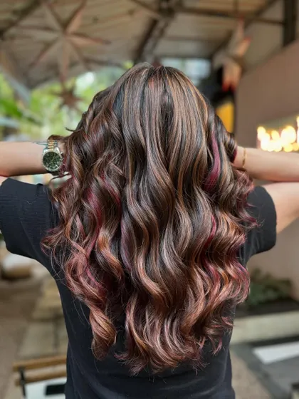 This balayage has it all: rich brunette base, warm highlights, and a surprise pop of red. It’s a look that’s both subtle and bold. (No filter)