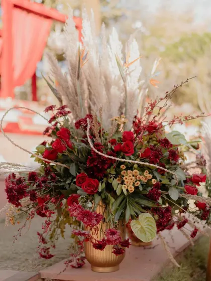 Another view of our lush, textured floral arrangements, combining fresh red roses and carnations with the airy quality of pampas grass.