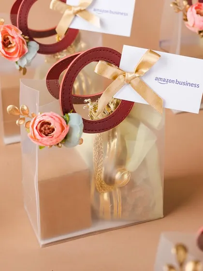 Elegant and modern Diwali gift bags for Amazon Business. The clear bag with floral accents and a custom tag is a chic and contemporary way to present festive gifts.