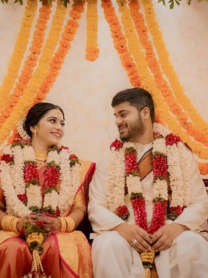 A classic portrait of the couple on the Oonjal (swing), a beautiful tradition in South Indian weddings, decorated with marigold garlands.