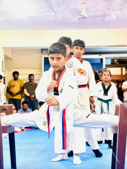 A student holds a split between two chairs.