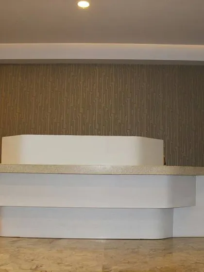 The reception table viewed from another angle, highlighting its asymmetrical design and the interplay of forms. This piece was designed to be visually engaging from all perspectives in the hotel lobby.