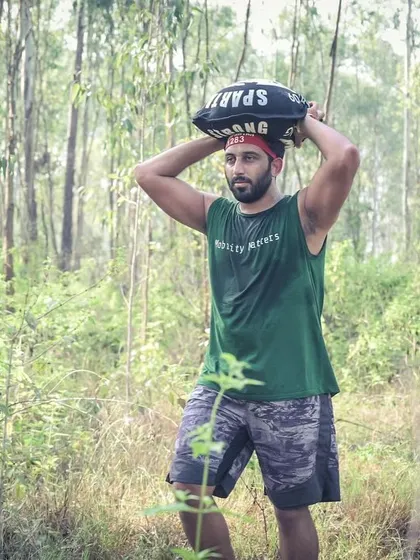 Carrying a heavy sandbag through the woods during the Spartan Race. This is a test of pure grit and strength.