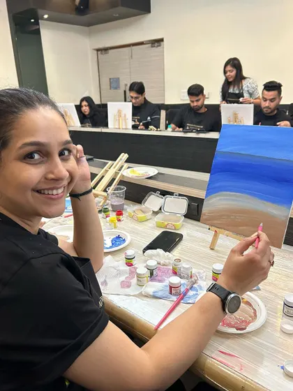 Another happy painter, turning to the camera for a quick photo while working on her art.