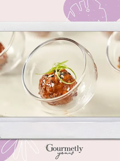 A gourmet meatball served in a stylish, angled glass bowl. This image is part of our "Delight in Every Bite" series, showcasing our elegant and flavorful appetizers.