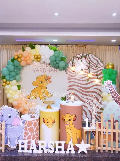 A Simba and Lion King inspired jungle theme. This setup features a custom backdrop with baby Simba, animal-print pedestals, and cute animal cutouts.