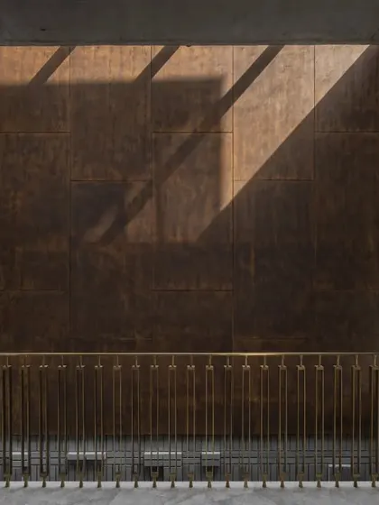 The weathered corten steel feature wall in the Swatantra Residence atrium creates a dramatic visual narrative. The play of light and shadow on its warm, earthy tones elevates the space into a show-stopping architectural experience.