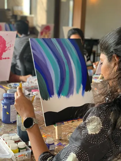 A painter adding the final touches to her aurora painting. The blend of blues and greens creates such a magical effect.