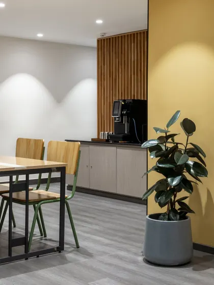 The office pantry area combines a butter-yellow wall with wood-paneled accents. I use color strategically to energize common areas and make them more inviting.