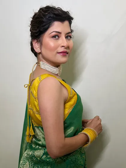 A side profile showing the intricate braided hairstyle and the glowing makeup. This look was designed to be elegant and eye-catching for the awards night.