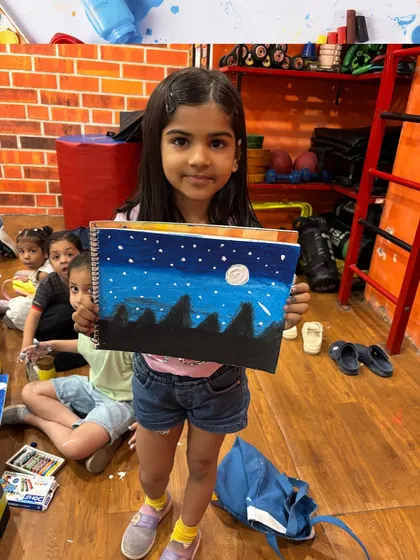 This young artist is happy to show her starry night sky painting. We encourage all our students to be proud of their creative accomplishments.