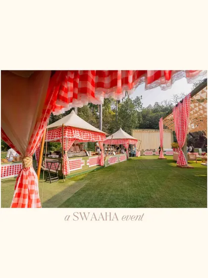 A wide shot of the baby shower setup, showing the charming food stalls and seating areas under checkered-print canopies.
